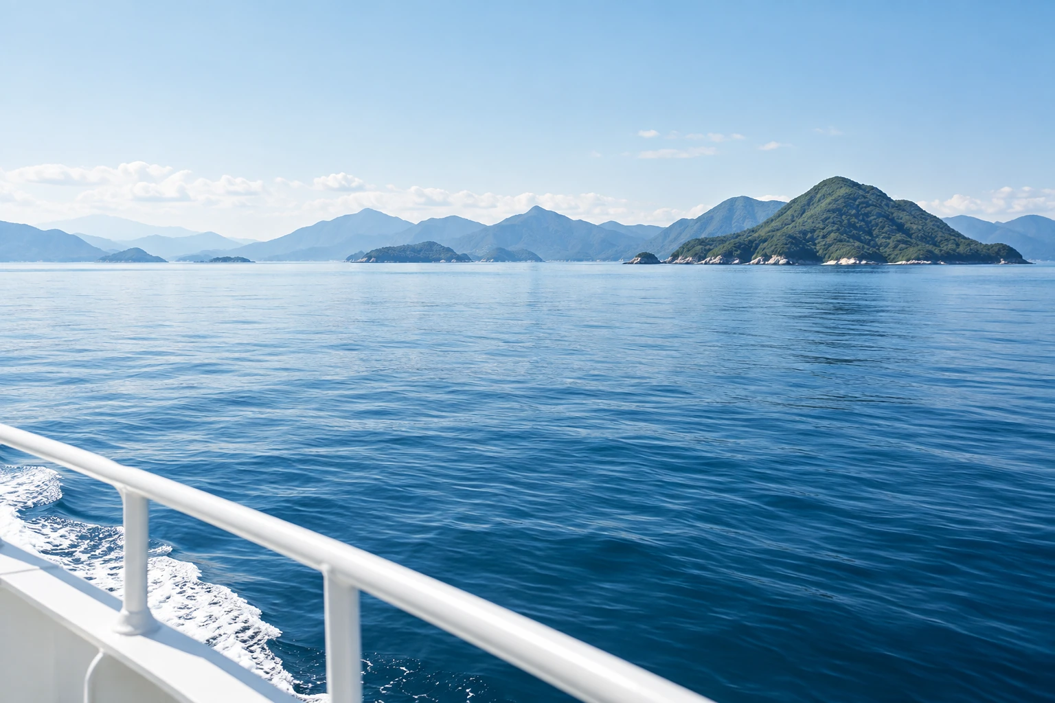 白い船縁から望む澄んだ海と島々